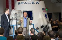 Илон Маск и Чарльз Болден стоят перед макетом DragonRider в штаб-квартире SpaceX, 2012