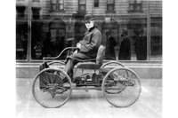 Генри Форд сидит в своём первом автомобиле Ford Quadricycle, 1896