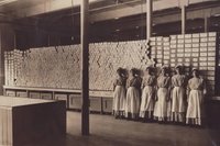 Работники хлопчатобумажной фабрики стоят перед повязками, изготовленными для помощи раненым солдатам, 1915 / источник: Johnson&Johnson Our Story (ourstory.jnj.com)