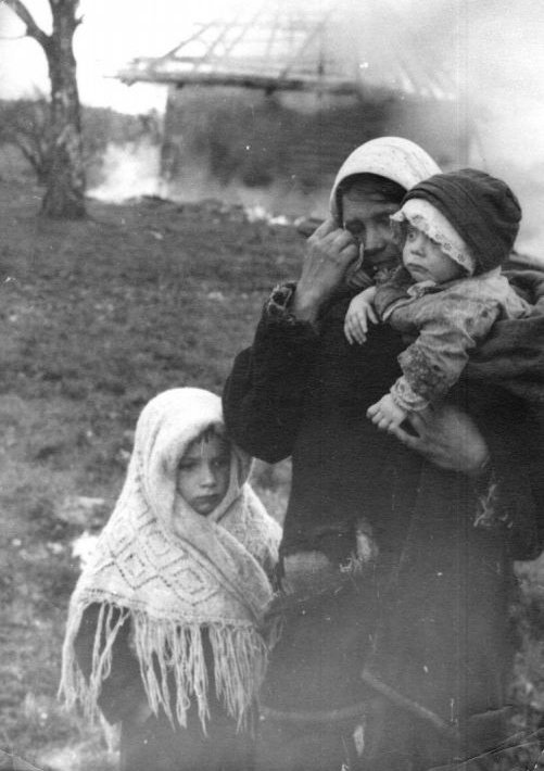 Жительница деревни Серболово с детьми на фоне сгоревшей хаты, 1942 г. Источник: Военный альбом (waralbum.ru)