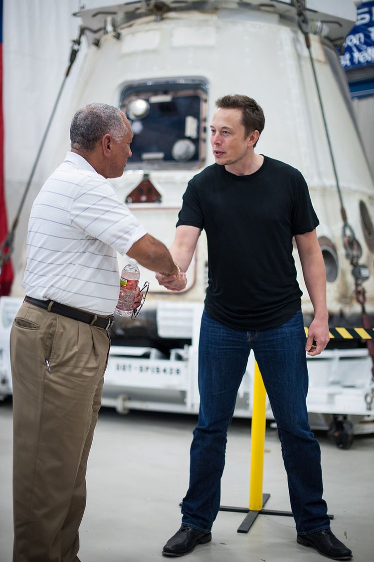 Администратор НАСА Чарльз Болден поздравляет генерального директора и главного конструктора SpaceX Илона Маска перед исторической капсулой Dragon, которая вернулась на Землю после первой успешной миссии частной компании по доставке грузов на Международную космическую станцию 13 июня 2012 года